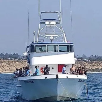 A group fishing on a white boat
